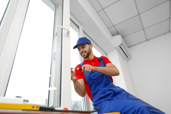 Trabajador joven instalando ventana en piso — Foto de Stock