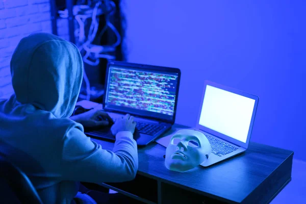 Hacker profissional usando laptop no quarto escuro — Fotografia de Stock