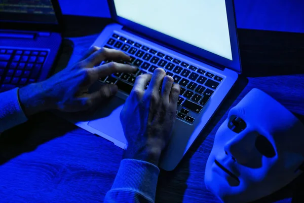Professional hacker using laptop in dark room, closeup — Stock Photo, Image