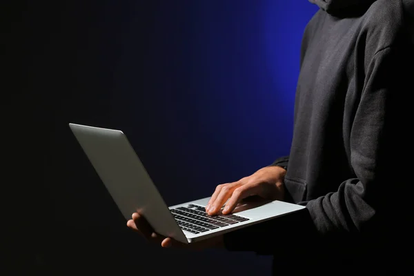 Hacker profissional com laptop no fundo escuro — Fotografia de Stock