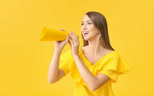 Young woman with paper megaphone on color background — Stock Photo, Image