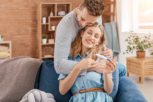Happy young couple with pregnancy test at home — Stock Photo, Image