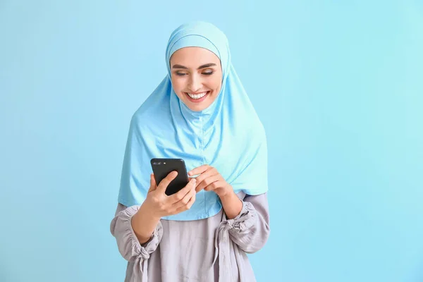 Mujer árabe hermosa con teléfono móvil en el fondo de color —  Fotos de Stock