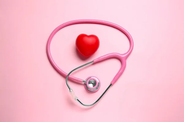 Modernes Stethoskop und rotes Herz auf farbigem Hintergrund — Stockfoto