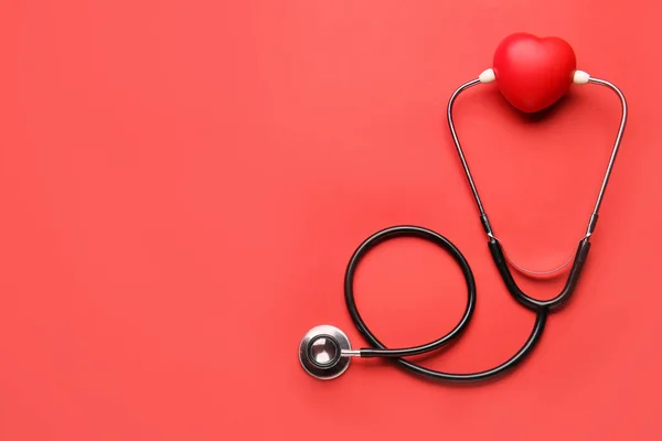 Stethoscope and heart on color background — Stock Photo, Image