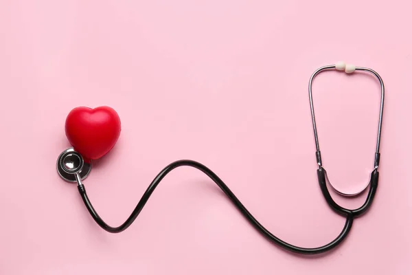 Stethoscope and heart on color background — Stock Photo, Image