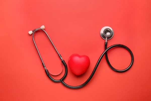 Stethoscope and heart on color background — ストック写真
