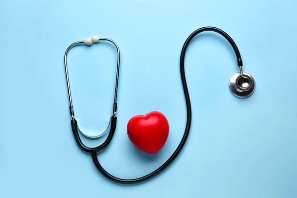 Estetoscópio e coração sobre fundo de cor — Fotografia de Stock