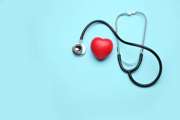 Stethoscope and heart on color background — ストック写真