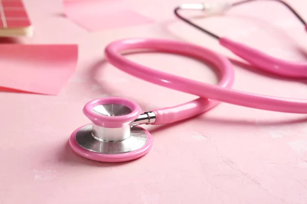 Stethoscope and paper sheets on color background — Stock Photo, Image