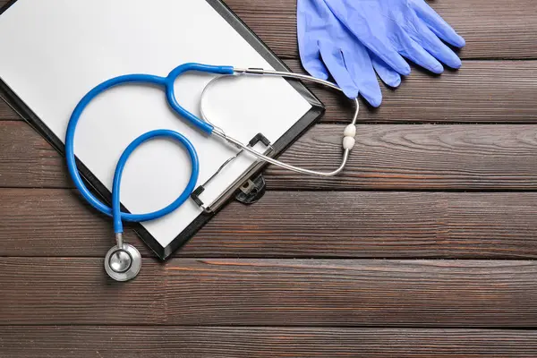 Stethoscope, clipboard and gloves on table — Stock Photo, Image