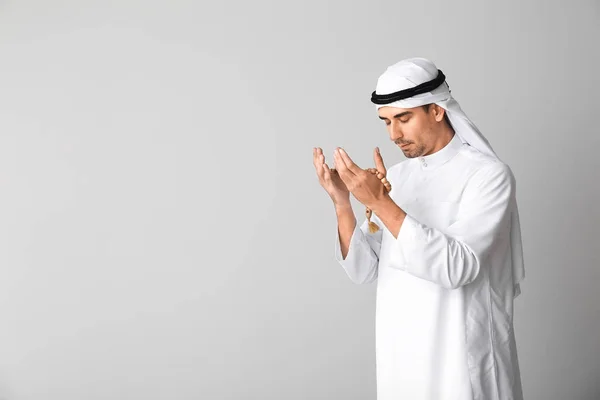 Hombre árabe guapo rezando sobre fondo claro — Foto de Stock