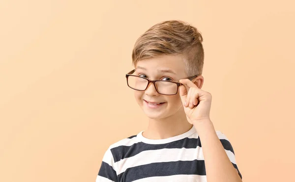 Cute little boy with eyeglasses on color background — 스톡 사진