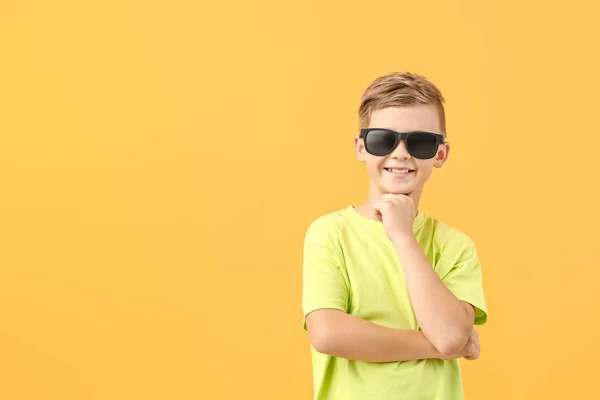 Cute little boy with sunglasses on color background — Stock Photo, Image