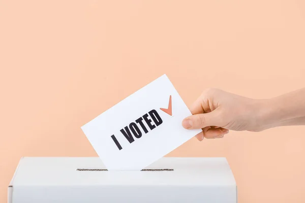 色の背景の投票箱の近くの投票の女性 — ストック写真