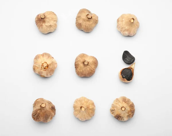 Black garlic on white background. Concept of uniqueness — 스톡 사진