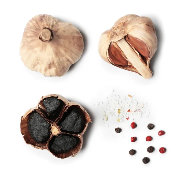 Black garlic and spices on white background — Stock Photo, Image