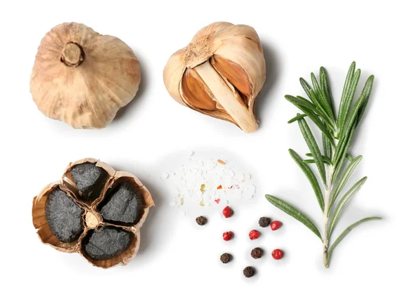 Black garlic, herbs and spices on white background — Stock Photo, Image