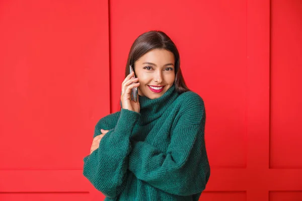 Young woman talking by mobile phone on color background — Stock Photo, Image