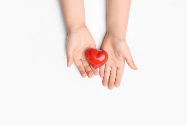 Mani di bambino con cuore rosso su sfondo bianco. Concetto di cardiologia — Foto Stock