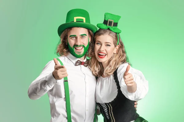 Young couple showing thumb-up on color background. St. Patrick's Day celebration — 스톡 사진