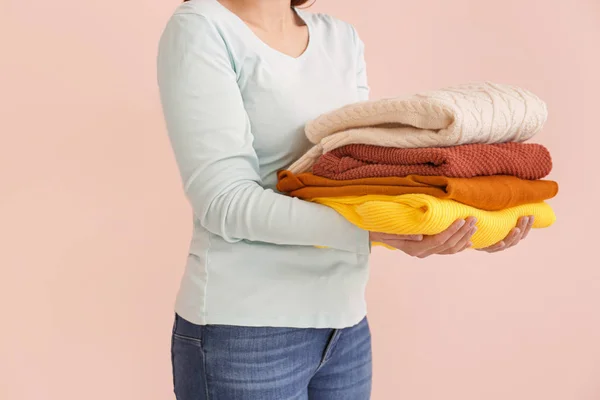 Young woman with clean laundry on color background — Stock Photo, Image