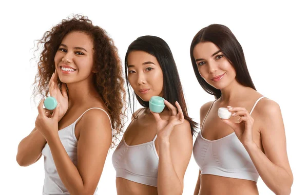 Hermosas mujeres jóvenes con crema sobre fondo blanco — Foto de Stock