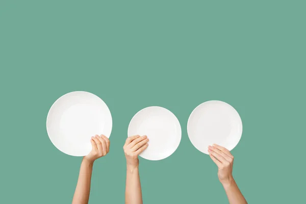 Hands with clean plates on color background — Stock Photo, Image