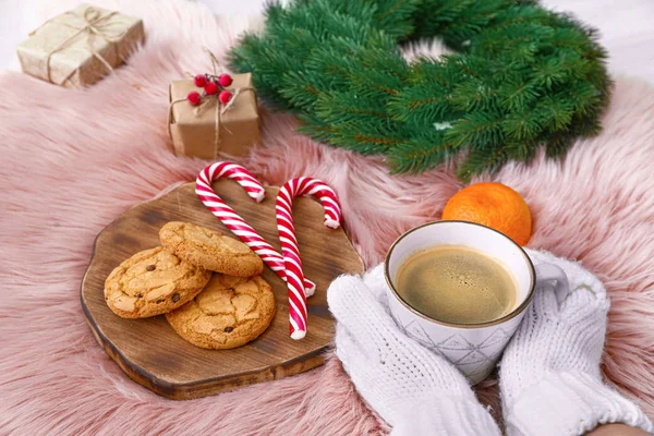 Жіночі руки з чашкою кави, печивом та різдвяним декором на м'якій плед — стокове фото