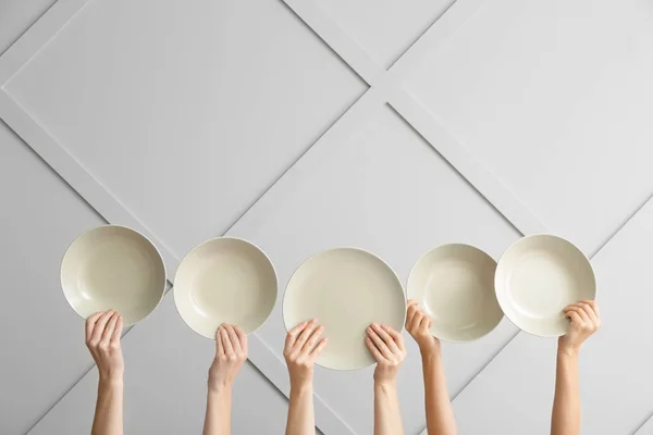 Hands with clean plates on light background — Stock Photo, Image