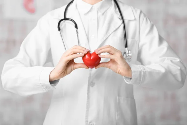 Cardióloga femenina con corazón rojo sobre fondo claro — Foto de Stock