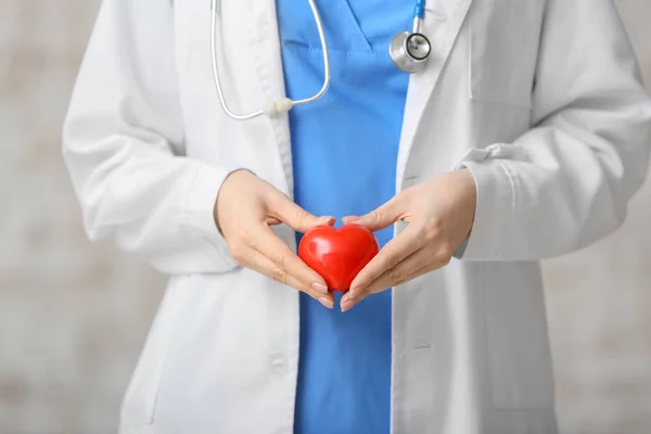 Kardiolog z czerwonym sercem na jasnym tle — Zdjęcie stockowe