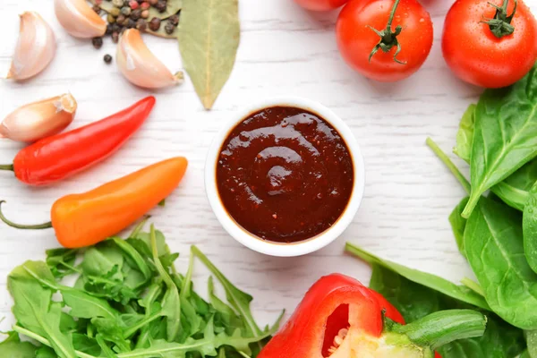 Samenstelling met lekkere barbecuesaus en groenten op tafel — Stockfoto