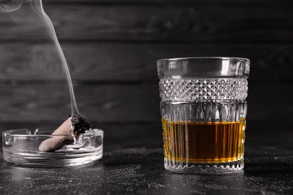 Bicchiere di alcol e sigaro sul tavolo. Concetto di cattive abitudini — Foto Stock