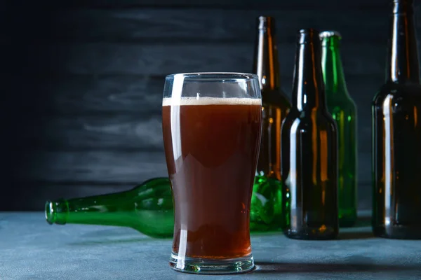 Glass and bottles of beer on table. Concept of alcoholism — Stock Photo, Image