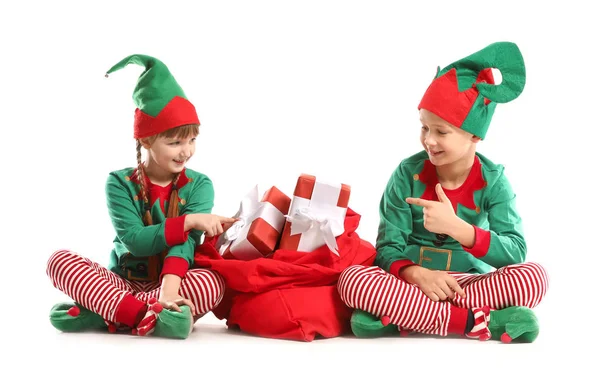 Małe dzieci w stroju elfa i z torbą Świętego Mikołaja pełne prezentów na białym tle — Zdjęcie stockowe