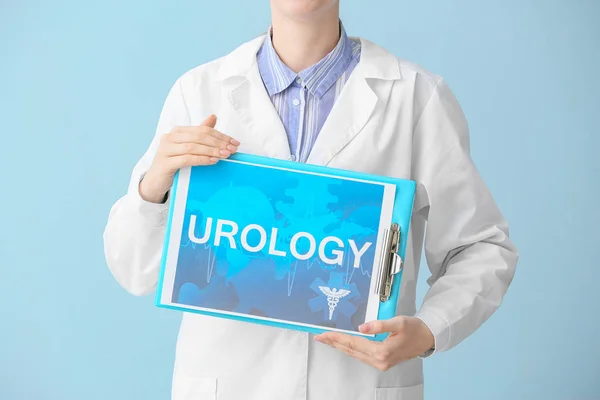 Врач держит бумагу с текстом UROLOGY на светлом фоне — стоковое фото