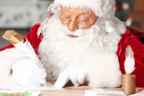 Weihnachtsmann bastelt Geschenkliste im weihnachtlich dekorierten Zimmer — Stockfoto
