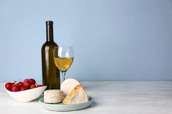 Свежий сыр и вино на белом столе — стоковое фото