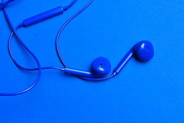 Blue earphones on color background — Stock Photo, Image