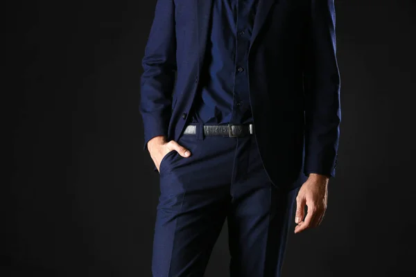 Человек в стильной синей одежде на тёмном фоне — стоковое фото