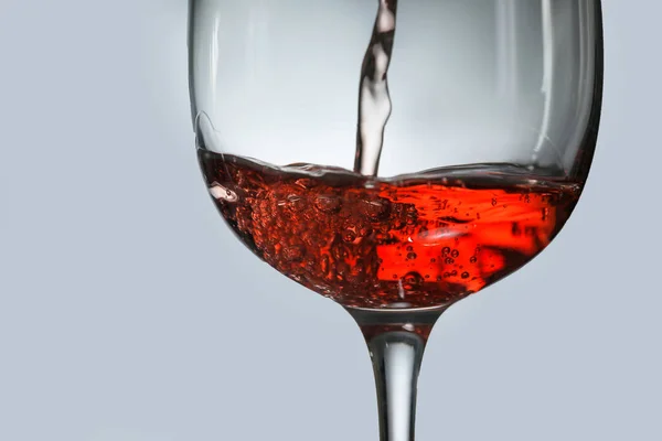 Nalití chutného vína do skla na šedém pozadí, detailní záběr — Stock fotografie
