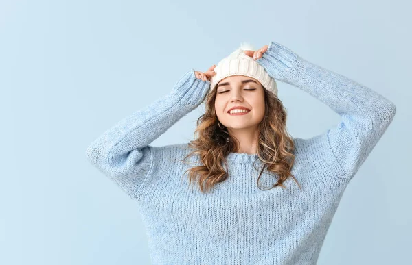 Bella giovane donna in maglione caldo su sfondo di colore — Foto Stock