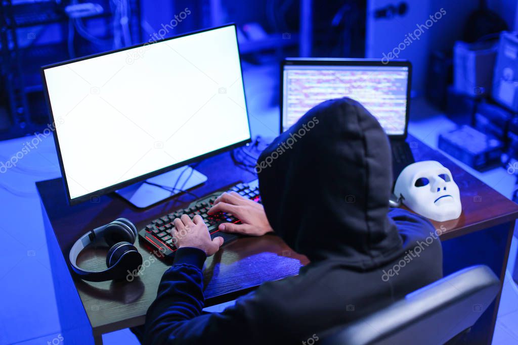 Professional hacker using computer in dark room