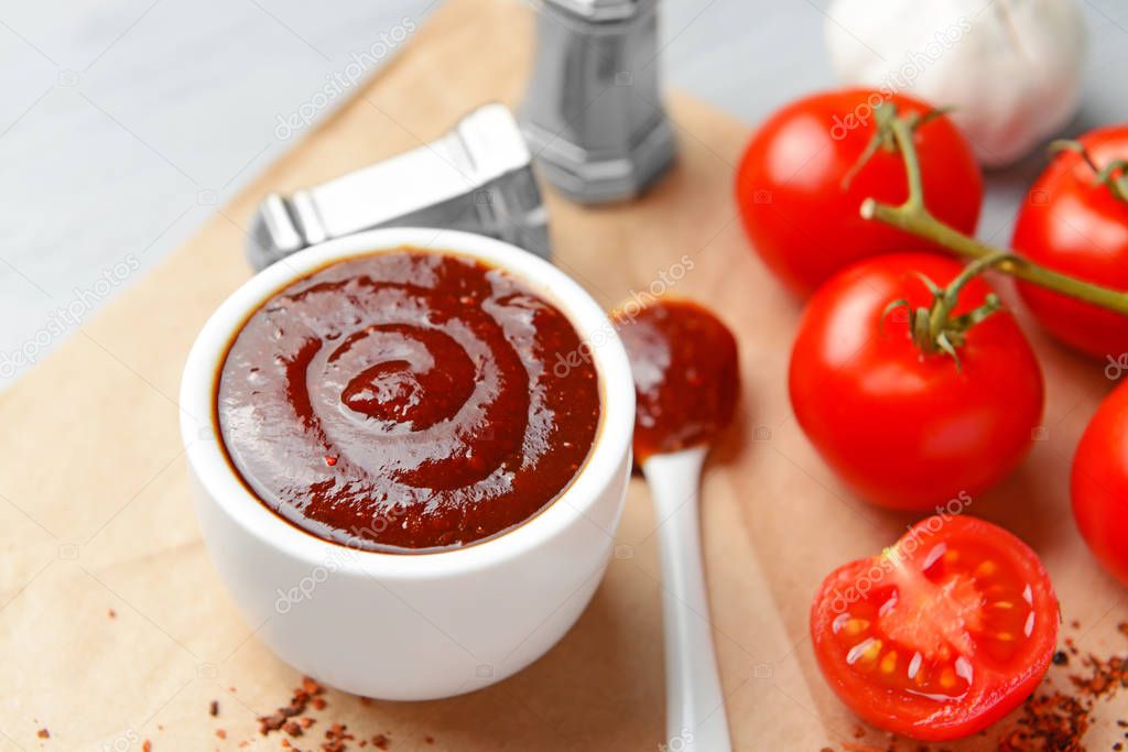 Bowl with tasty barbecue sauce on table