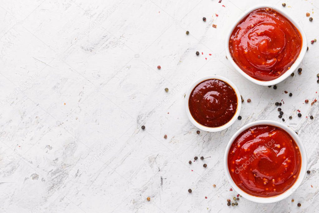 Bowls with tasty barbecue sauce on table
