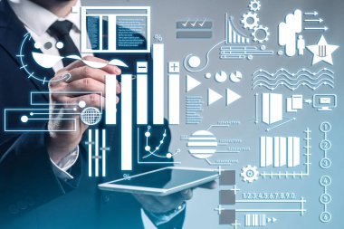 Tablet bilgisayarlı bir iş adamı gri arka planda sanal ekran kullanıyor. Modern iş teknolojileri kavramı