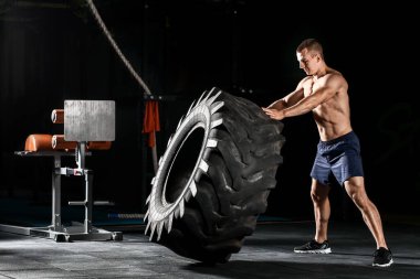 Spor salonunda lastiği patlayan kaslı bir adam.
