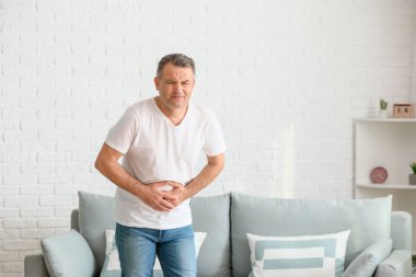 Evde karın ağrısı çeken olgun bir adam.