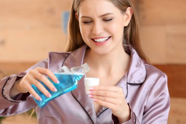 Banyoda ağzını çalkalayan güzel bir genç kadın.